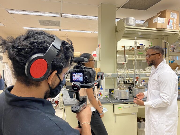 Rutgers Plant Biology graduate student Marcus Rountree is interviewed by high school student Kayla Soto while Brendan Jenkins videotapes. Photo credit Claudia Urdanivia