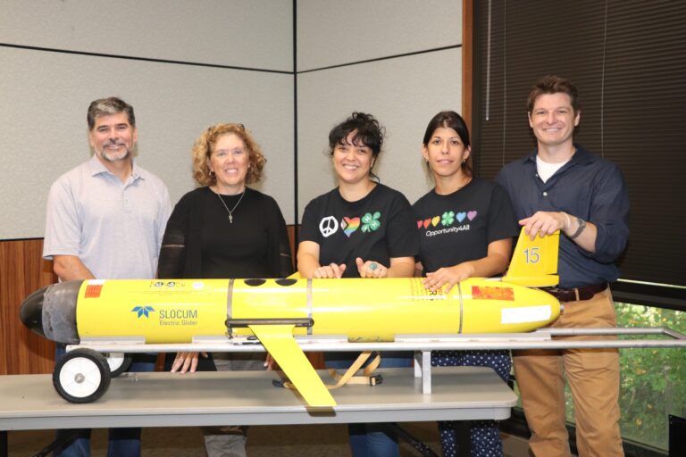 Left to right: Josh Kohut of the Dept. of Marine and Coastal Sciences, and Janice McDonnell, Alesha Vega, Marissa Staffen, and Matt Newman of Rutgers Cooperative Extension-4-H Youth Development. They are standing behind an RU COOL ocean exploring glider.